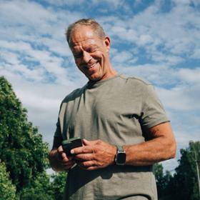 Man tittar ner i en mobiltelefon.